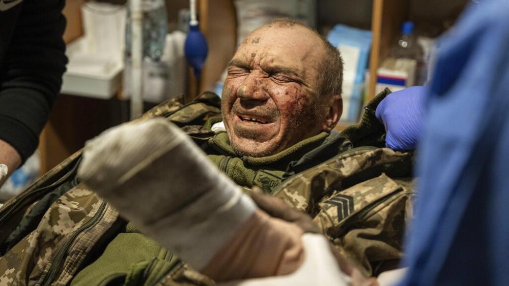 A wounded Ukrainian serviceman aka Alpha is treated at the field hospital near Bakhmut, Ukraine, Sunday, Feb. 26, 2023. (AP Photo/Evgeniy Maloletka)