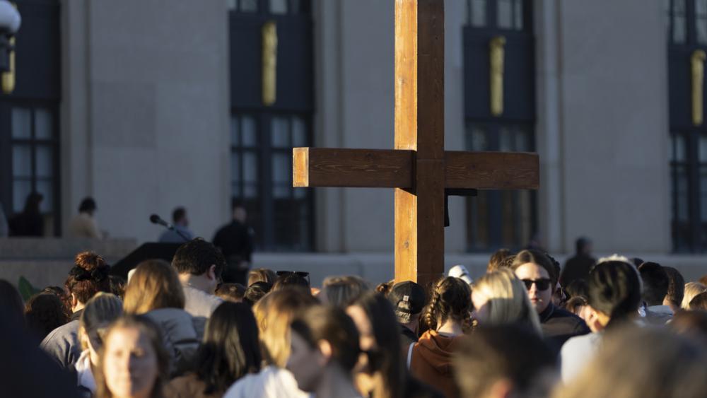 A cross stands above the crowd during a vigil held for victims of The Covenant School shooting on Wednesday, March 29, 2023, in Nashville, Tenn. (AP Photo/Wade Payne)