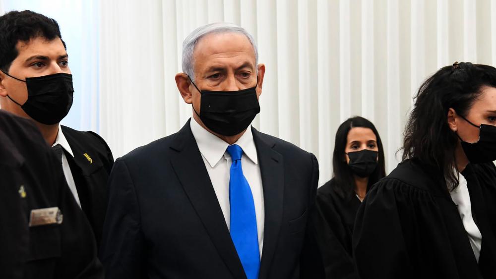 Israeli Prime Minister Benjamin Netanyahu stands at a hearing at the district court in Jerusalem, Monday, Feb. 8, 2021. (AP Photo/Reuven Castro, Pool)