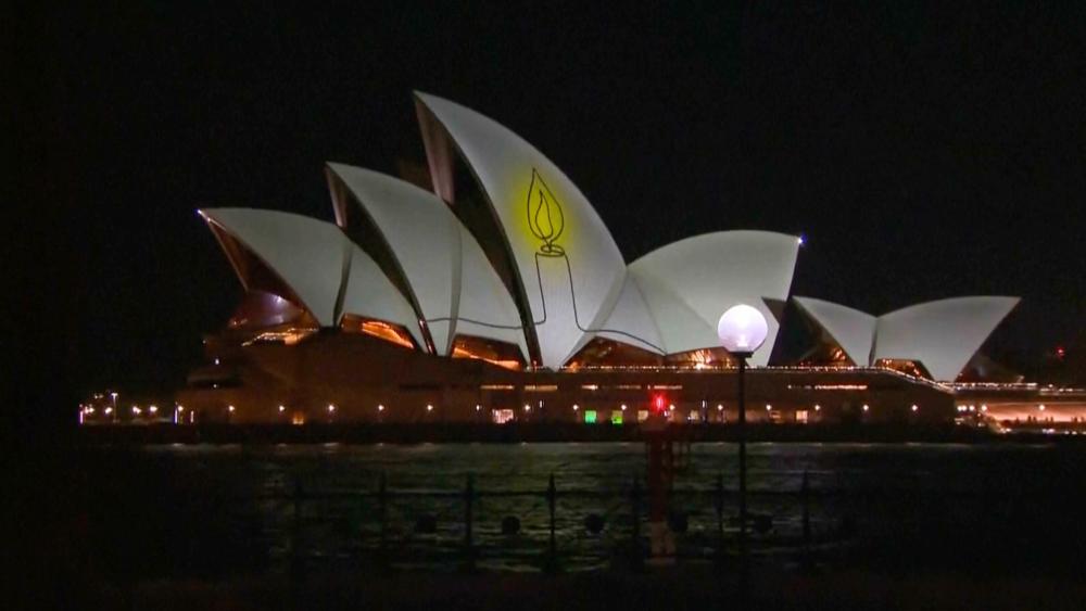 The Sydney Opera House is illuminated with a candle as Australia marks a day of reflection in Bondi following the Hanukkah terror attack. Dec. 21, 2025. Photo credit: Screenshot, Australian Parliament TV/AP.