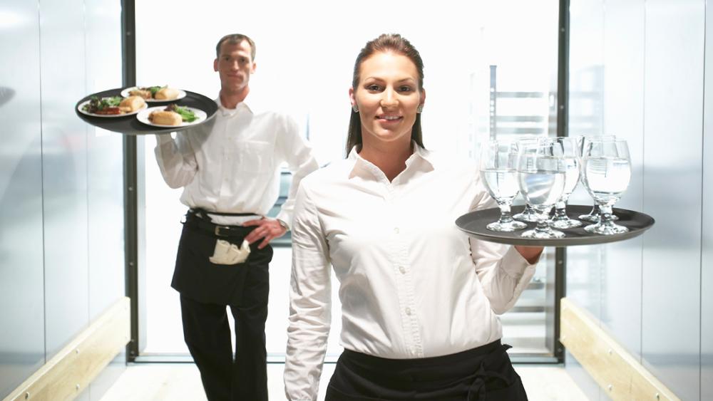 waitress and waiter carrying food and drinks
