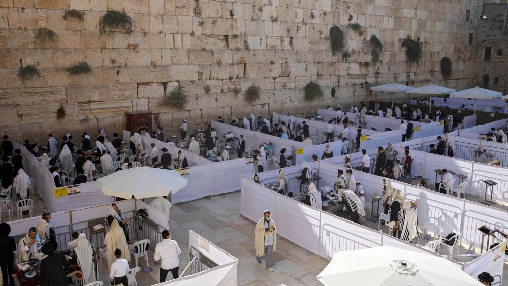 Ultra-Orthodox Jewish men pray in divided sections which allow a maximum of twenty worshipers, at the Western Wall. (AP Photo/Sebastian Scheiner)